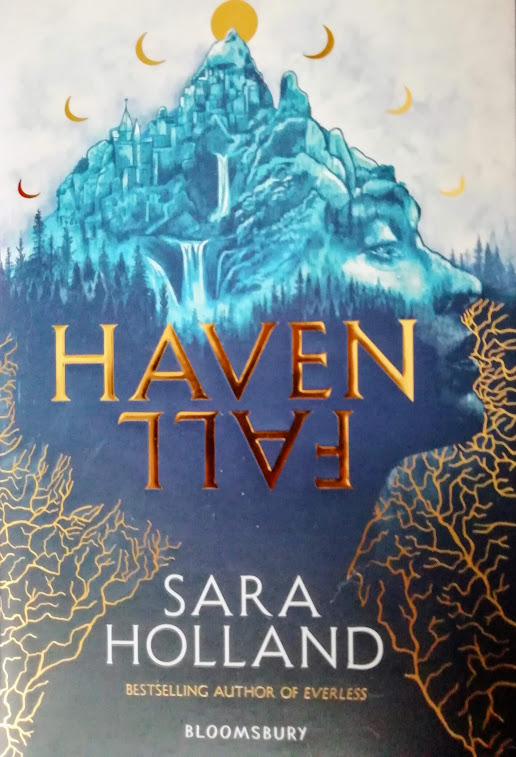De cover een blauwe berg met de vorm van een gezicht met gouden manen erboven en Havenfall en Sara Holland ervoor